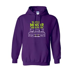 Purple hoodie with neon green text 'There's a monster under my bed' and a white bed illustration peeking with glowing eyes underneath spot.