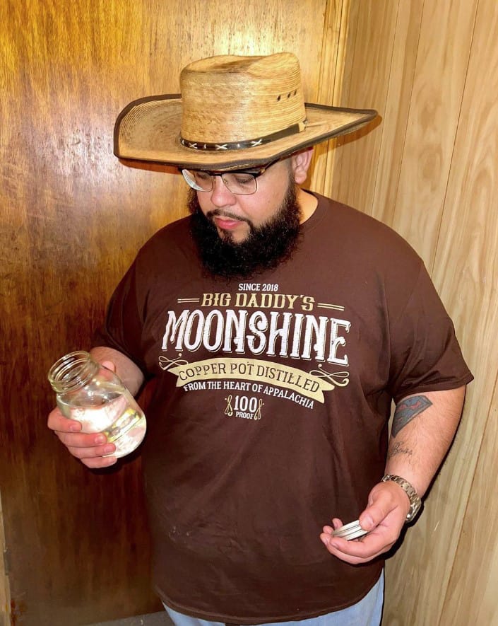 A man wearing Big Daddy's Moonshine Tee in brown in size 4XL