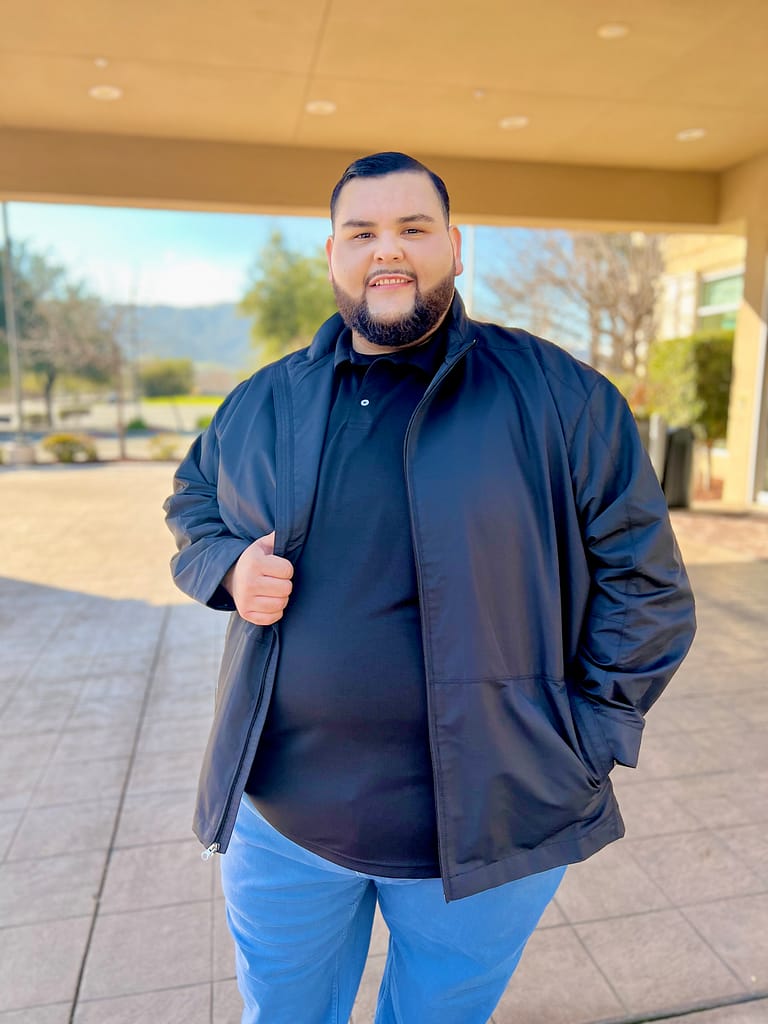 A man wearing the Big Daddy Basics Polo in black in size 6XL