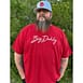 Man standing outside wearing a Big Daddy Signature Tee in Red and a Big Daddy Puff logo hat in white
